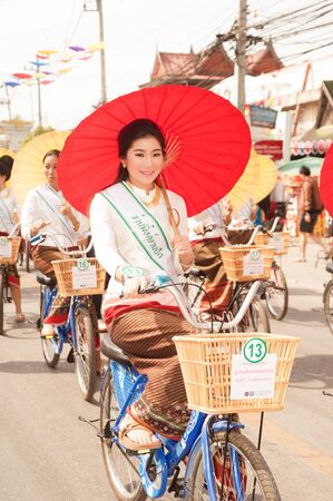 Pretty woman in traditional dresses ride a bicycle parade show in Umbrella Festival .のeditorial素材