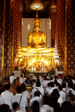 Buddhist Thai peoples worship of Phra Buddha Nimitr Vichit Maramoli Sisanpeth Boromtrailokanat, Main Buddha Image at Wat Na Phrameru. The Buddha wears the Royal Attire, typical for the late period of Ayutthaya Historical Park of Thailand.                 のeditorial素材