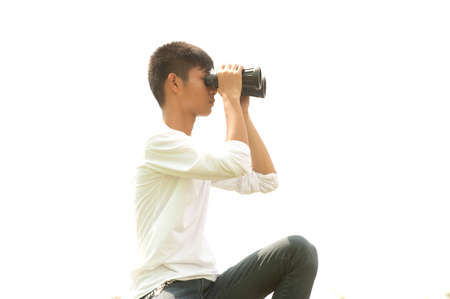 Asian young boy using binoculars .