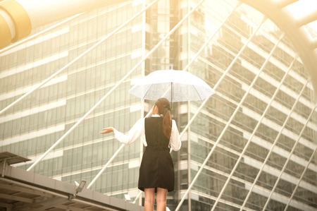 Thai pretty woman in black dress holding transparent umbrella walking on bridge crossing landmark in Bangkok,Thailand.の写真素材