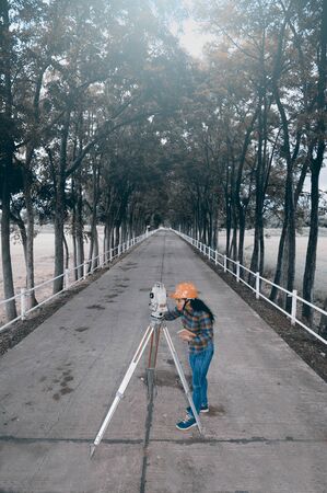 Female Surveyor or Engineer making measure on the field.の写真素材