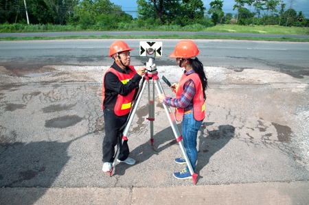 Surveyor or Engineer making measure with partner on the highway.の写真素材