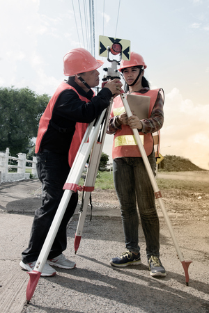 Surveyor or Engineer making measure with partner on the highway.の写真素材