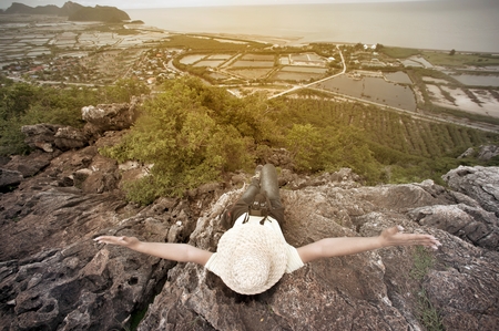Happy female lying on top of mountain is tourists view point and freedom.の写真素材