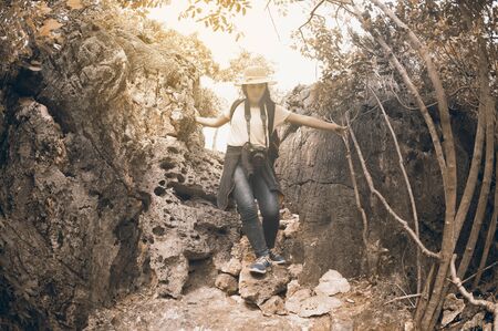Pretty Asian woman hiking and climbing in mountains adventure and exercising. Young fitness woman...