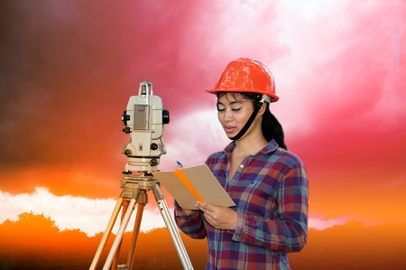 Female Surveyor or Engineer making measure by Theodolite on the field.の写真素材