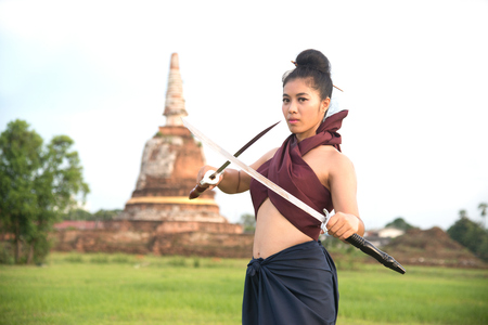 Pretty Asian woman posing in Thai ancient warriors at Wat Chang ancient abandoned temple in Ayutthaya Historical Park ,Thailand.の写真素材
