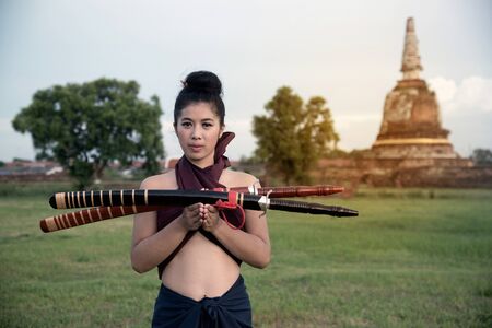 Pretty Asian woman posing in Thai ancient warriors at Wat Chang ancient abandoned temple in Ayutthaya Historical Park ,Thailand.の写真素材