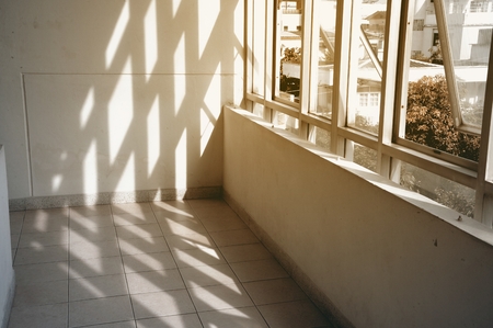 Concrete walls and window glasses with sun light and shadows.の写真素材