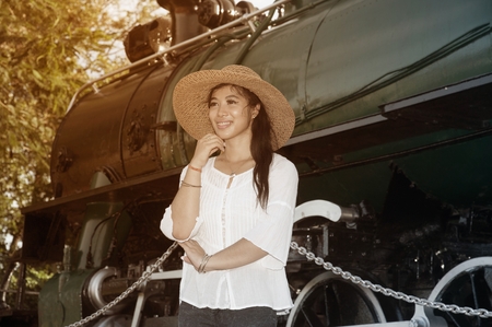 Pretty Asian Women standing and posing at Steam locomotive.の写真素材