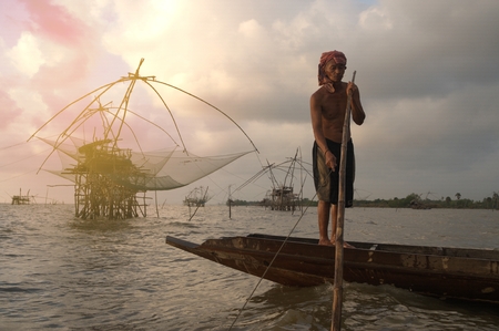 PHATTHALUNG,THAILAND-JUNE 6 ,2016 : Unidentified fisherman is punting his wooden boat in Ban Pak Pra -Talay Noi Lake, Phatthalung Province, Thailand.のeditorial素材