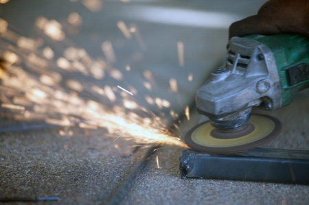 The worker is welding metal part of table steel in factory.の写真素材