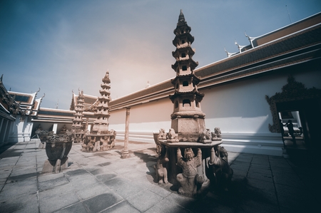 The art of buildings and many ornate chedis at the Wat Pho temple in Bangkok during a sunny day ....