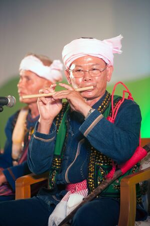 PHAYAO,THAILAND-MAY 9,2015 : Unidentified Tai Lue minority male musician performs with traditional clothes playing a bamboo flute showing in 8th Ethnic amazing festival at Chiangkum,Phayao ,Thailand.のeditorial素材