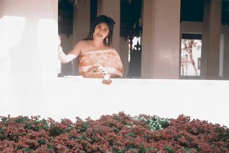 The pretty Thai lady in Middle Thai classical traditional dress suit standing hold garland  is...