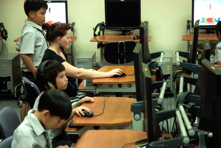 à¸ºBANGKOK,THAILAND - MARCH 23,2009 : Unidentified young Asian students are learning to use computer at elementary in classroom at Amnuay Silpa school , Bangkok capital city, Middle of Thailand.のeditorial素材