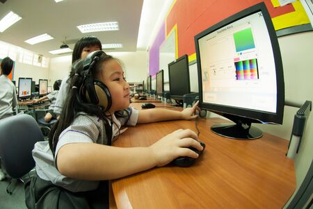 à¸ºBANGKOK,THAILAND - MARCH 23,2009 : Unidentified young Asian students are learning to use...