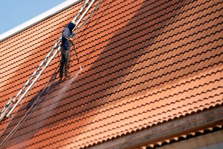Rooftop worker with professional equipment Cleaning the roof of the house with a pressure tool.のeditorial素材