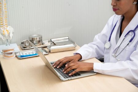 African female doctor with stethoscope standing with a red heart symbol Which means looking after your health with care.の写真素材