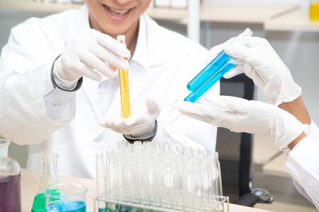 Two scientists are working in laboratory. Young female researcher and her senior supervisor are...