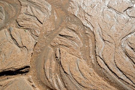 Natural sand patterns in beach at low tide.