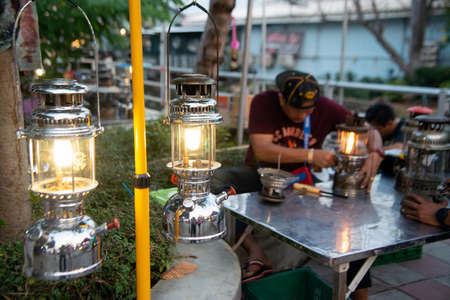 NAKORN PATHOM, THAILAND - FEBRUARY 22 , 2020 : Unidentified male is repairing the old hurricane lamp...