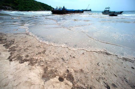 RAYONG,THAILAND-FEBRUARY 8,2013 :  Black crude oil on the beach Which is harmful to the environment...