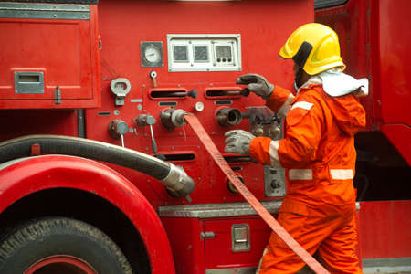 The fireman is preparing to put out the fire at the fire engine. Because the fire was burning in the...
