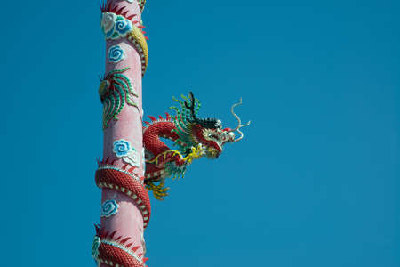 The pillars with stucco dragons wrapped around them are the art of Chinese shrines.の写真素材