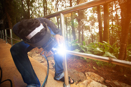 Welders weld metal fences by welding machines.