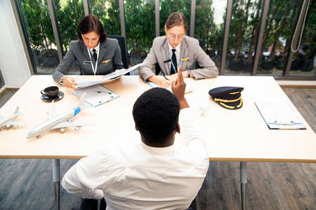 Aviation worker interviewing male job applicants At work on the ground.