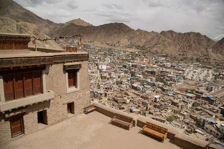 The corner top view and details of the grey stone and wooden doors and windows , the balconies have...