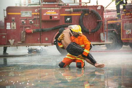 PHICHIT , THAILAND - AUGUST 29 ,2020 : Unidentified firefighters were trained to help the man who had suffered a fire and passed out. Leave a lot of scorching and smoke.のeditorial素材