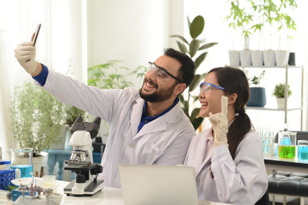Scientist or chemist taking a selfie with a cell phone With the joy after the successful work in the laboratory and research.の写真素材