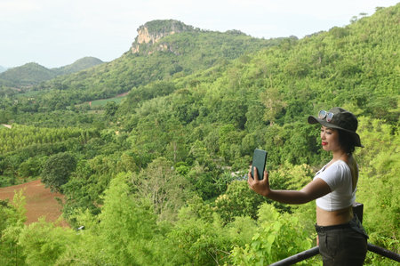 Beautiful Asian tourist woman taking selfie with mobile phone.