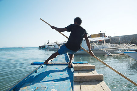 People used bamboo poles to push into the ground to make the ship move forward.の写真素材