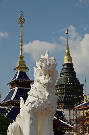 Statues of white Singha, which are animals in Thai art, decorate the front of the pagoda at Wat Den...