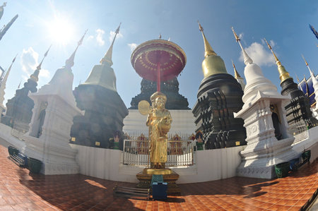 The golden monk statue front of Stupa of the Twelve Zodiac Signs reflects the beliefs of the twelve...
