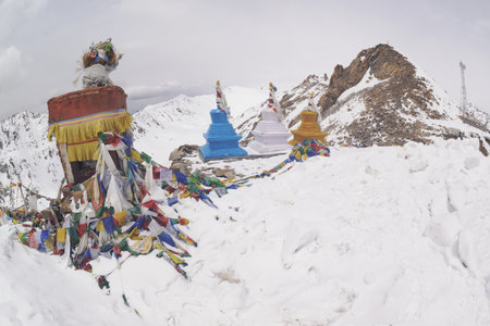 Prayer flags at a small religious site at Khardung La. This pass is located in the Ladakh mountains north of Leh and is the highest motorable road in the world.の写真素材