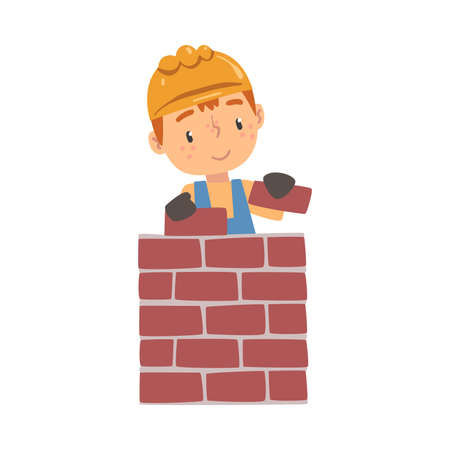 Boy Construction Worker Laying Bricks in Wall, Cute Little Builder Character Wearing Blue Overalls and Hard Hat Cartoon Style Vector Illustrationのイラスト素材