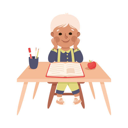 Little Boy Pupil Sitting at Table with Book Engaged in Elementary Education Vector Illustrationのイラスト素材