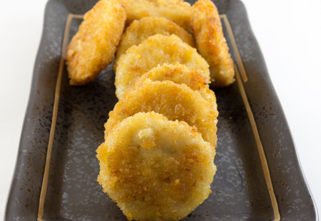 image of the chicken nugget in a black dish on a white background