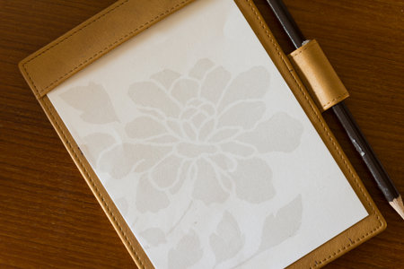 background, texture of notebook paper with pencil on wood tableの写真素材