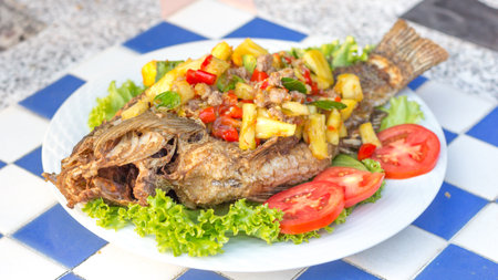 the fried fish with sweet and sour sauce is delicious food on the tableの写真素材