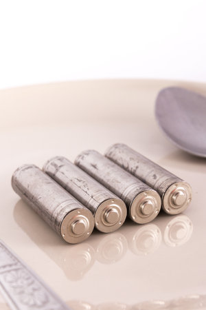 the isolated of old AA battery in food dish is energy consumption conceptの写真素材