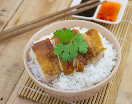 Grilled chicken  served on rice with sauce on wood backgroundの写真素材