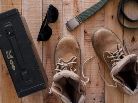 Still life art photography concept with boots ,belt ,sunglasses and metal bullet box on wood backgroundの写真素材