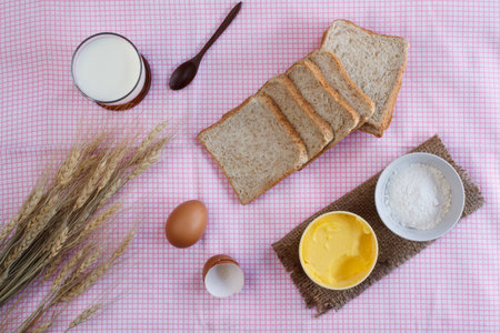 Stiil life with whole wheat bread,egg,magarine,flour and wheat on table