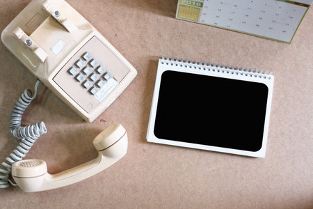 Still life concept with notepad and telephone.Top viewの写真素材