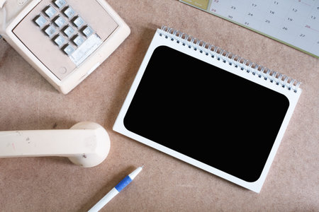 Still life concept with notepad and telephone.Top viewの写真素材